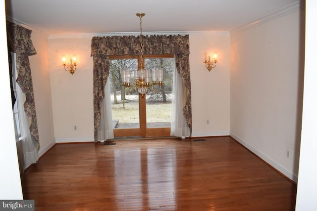 unfurnished dining area featuring hardwood / wood-style flooring, ornamental molding, and a chandelier