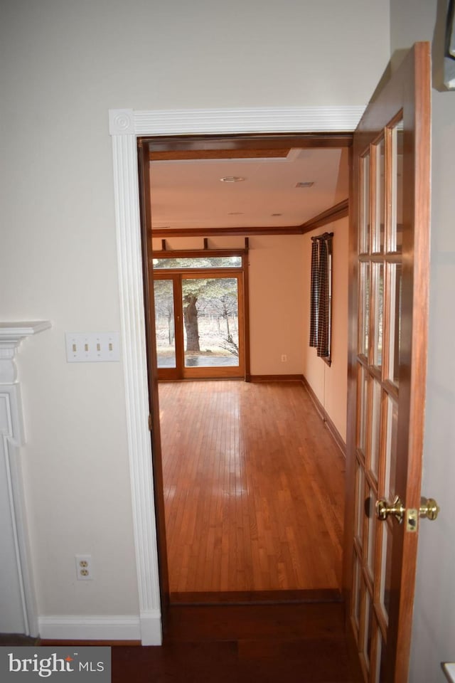 hallway featuring ornamental molding and light hardwood / wood-style flooring