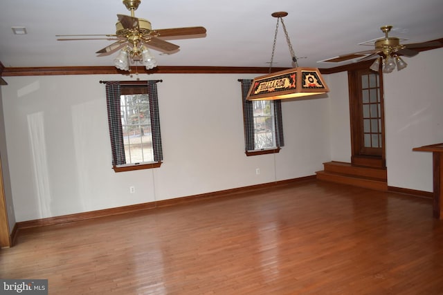 interior space with hardwood / wood-style floors, ornamental molding, and ceiling fan