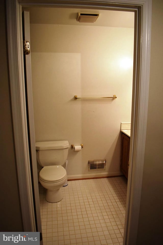 bathroom featuring tile patterned flooring, vanity, and toilet