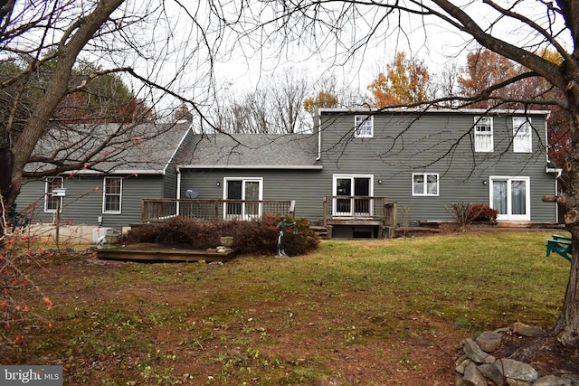 back of property featuring a lawn and a deck