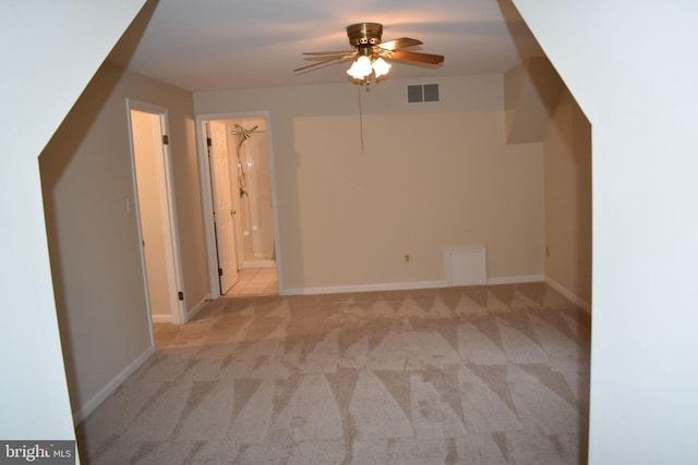 additional living space featuring light carpet and ceiling fan