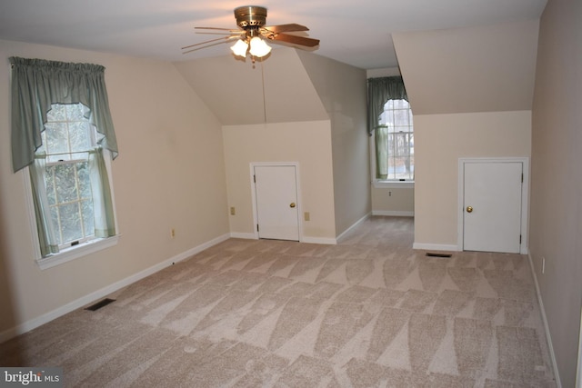 additional living space featuring ceiling fan, vaulted ceiling, and light carpet