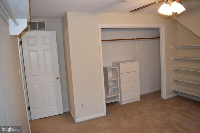 unfurnished bedroom with light colored carpet, ceiling fan, and a closet