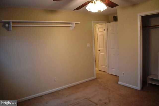 unfurnished bedroom featuring light colored carpet, a closet, and ceiling fan