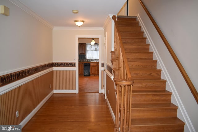 staircase featuring hardwood / wood-style flooring and ornamental molding