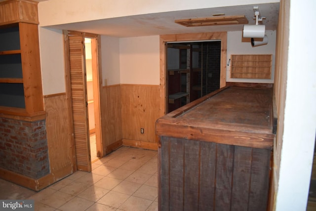 interior space featuring tile patterned floors and wood walls