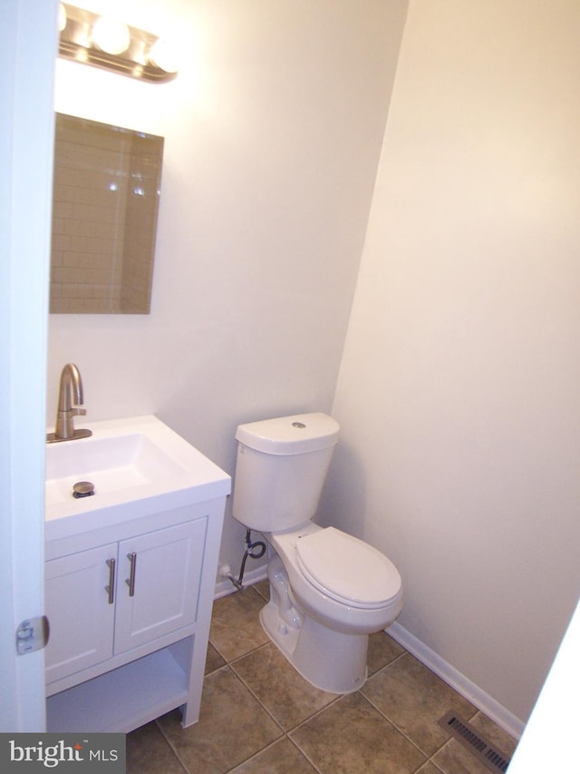 bathroom with toilet, tile patterned flooring, and vanity