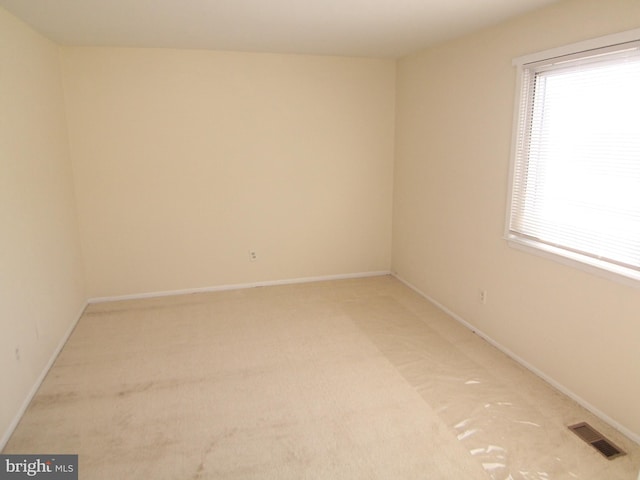 carpeted spare room featuring plenty of natural light