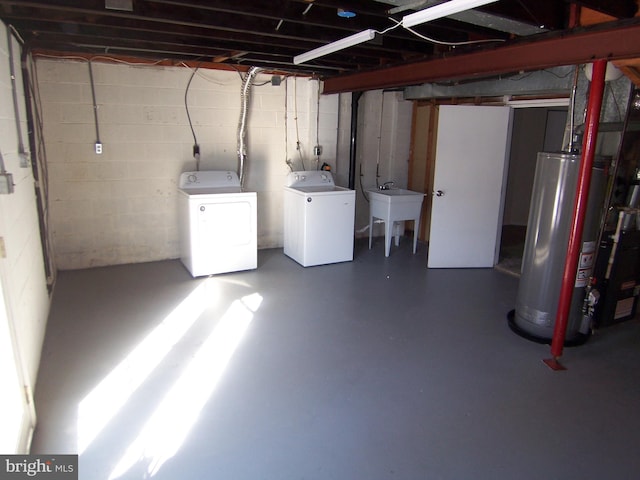 basement with sink, washer and clothes dryer, and gas water heater