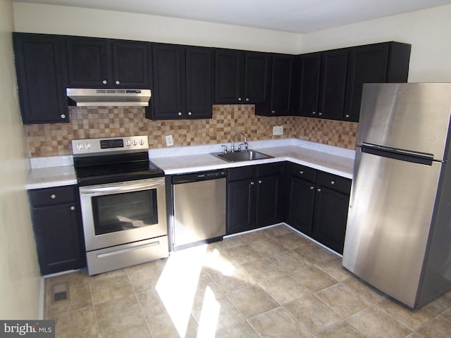 kitchen featuring light tile patterned floors, backsplash, sink, and stainless steel appliances