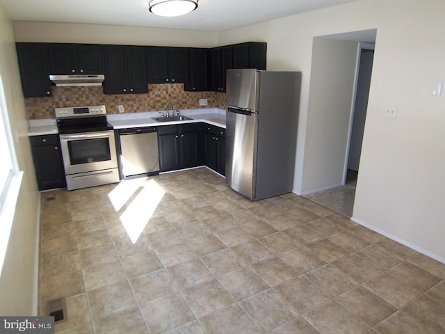 kitchen with light tile patterned floors, stainless steel appliances, decorative backsplash, and sink