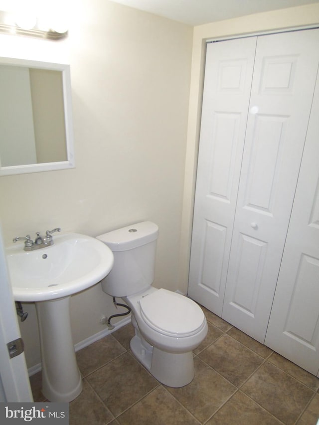 bathroom with toilet and tile patterned flooring