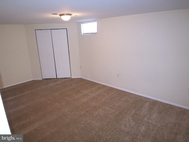 unfurnished bedroom with dark colored carpet and a closet