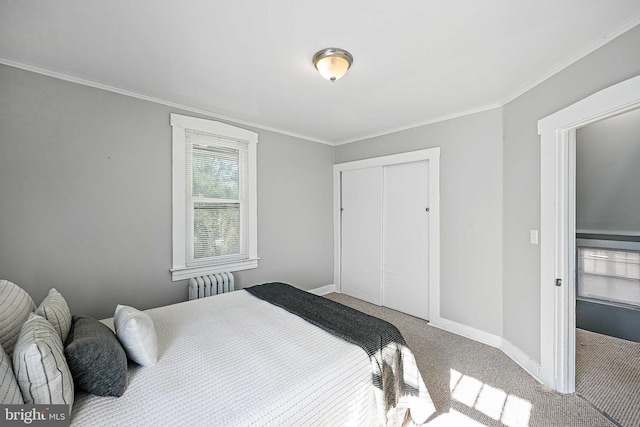 carpeted bedroom with a closet, radiator, and ornamental molding