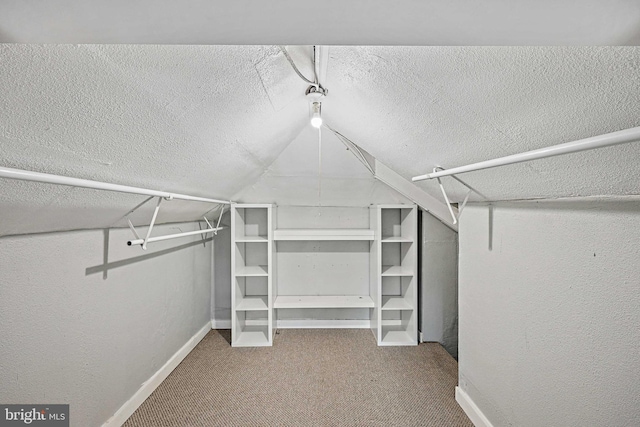 walk in closet with carpet flooring and vaulted ceiling