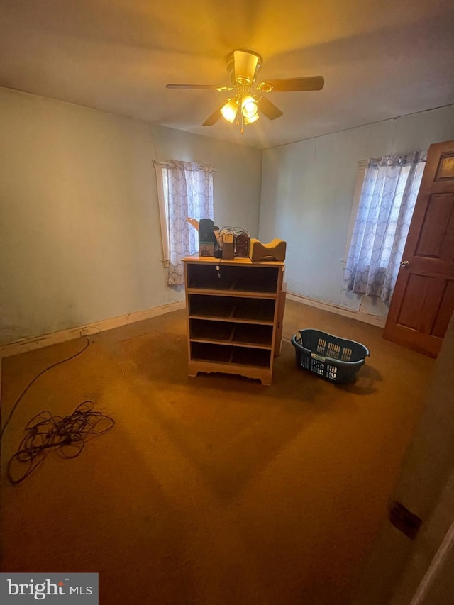 carpeted bedroom featuring ceiling fan and multiple windows