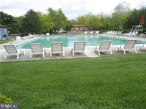 view of pool with a lawn