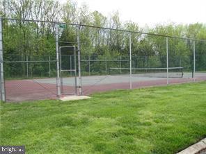 view of sport court featuring a lawn