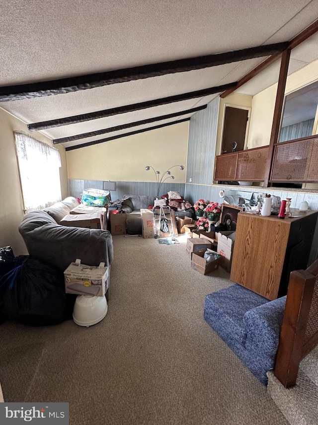 carpeted bedroom featuring lofted ceiling with beams and a textured ceiling