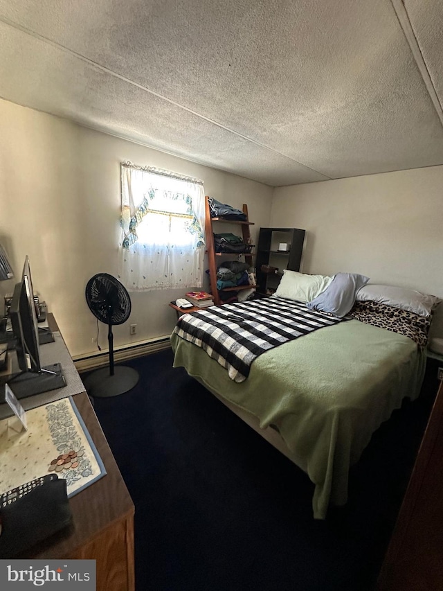 bedroom featuring carpet, baseboards, a baseboard heating unit, and a textured ceiling