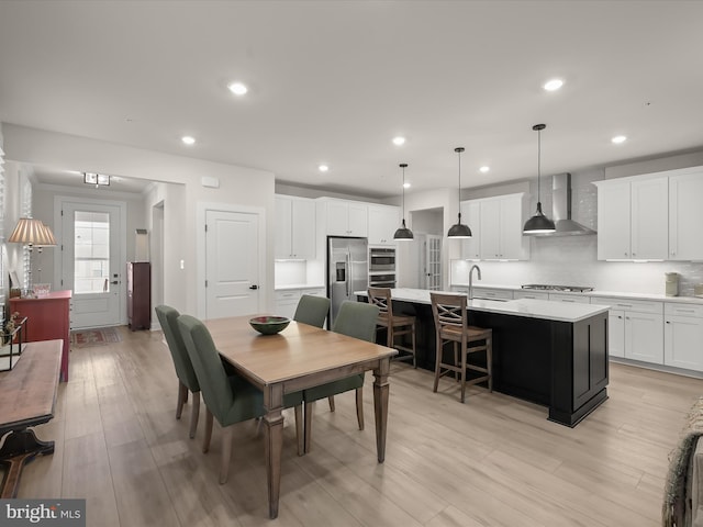 dining area with sink and light hardwood / wood-style floors