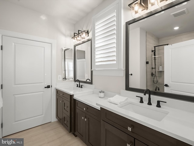 bathroom with wood-type flooring, an enclosed shower, and vanity