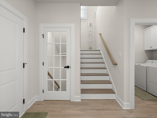 staircase with washer and dryer and hardwood / wood-style floors