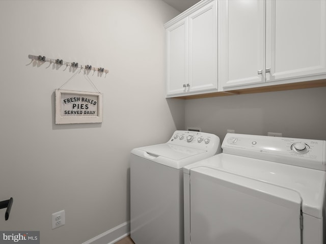 laundry area with independent washer and dryer and cabinets