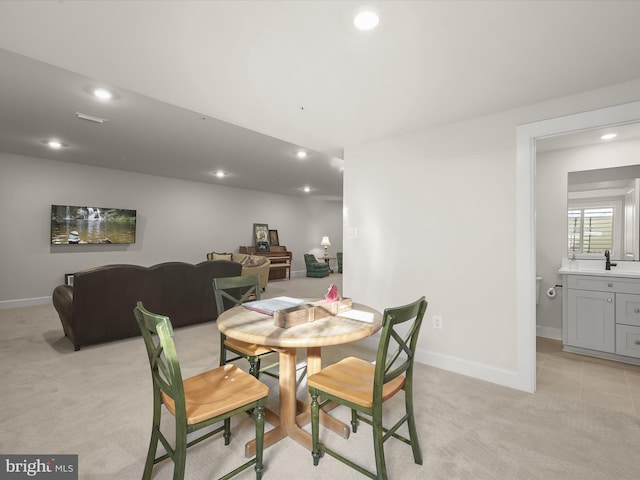 dining area with light colored carpet and sink