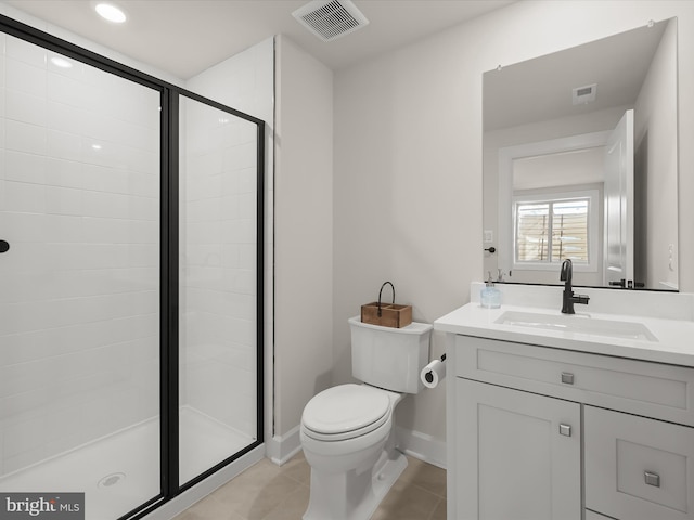 bathroom featuring tile patterned flooring, vanity, a shower with shower door, and toilet