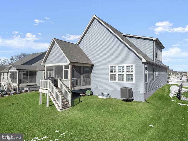 back of house featuring central AC unit, a yard, and a sunroom