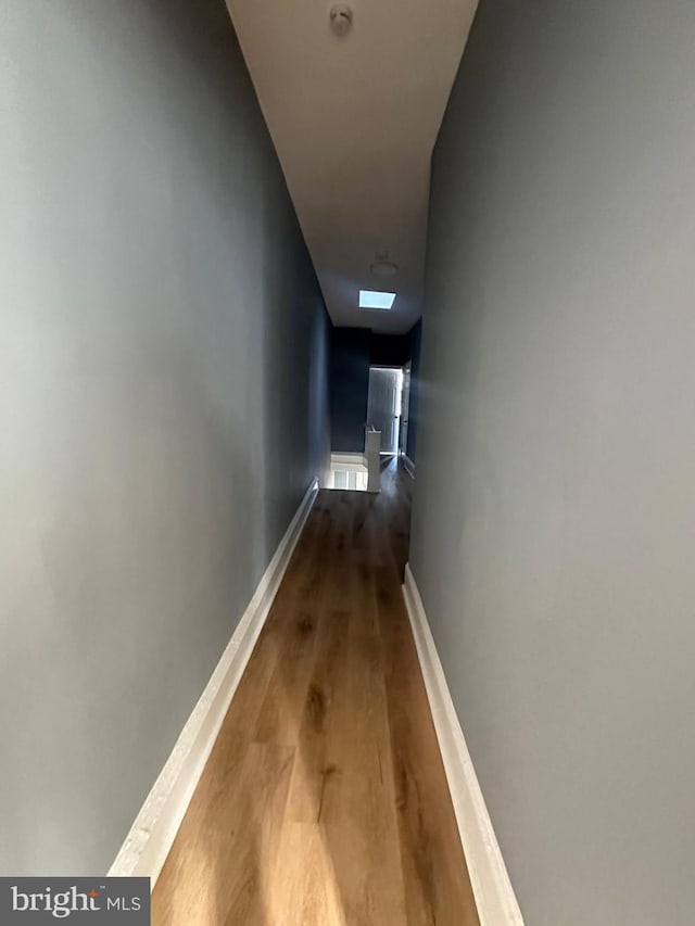 hallway with hardwood / wood-style flooring