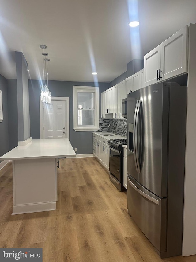 kitchen with pendant lighting, a center island, stainless steel appliances, tasteful backsplash, and white cabinets