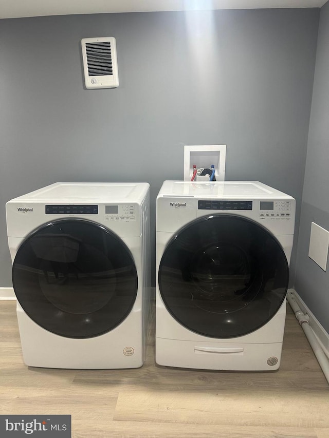 laundry room featuring washer and clothes dryer and light wood-type flooring