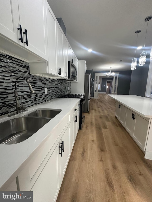 kitchen featuring decorative light fixtures, white cabinetry, a chandelier, and appliances with stainless steel finishes