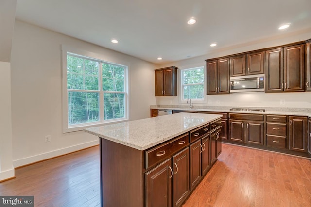 kitchen featuring a center island, appliances with stainless steel finishes, light hardwood / wood-style floors, and dark brown cabinetry