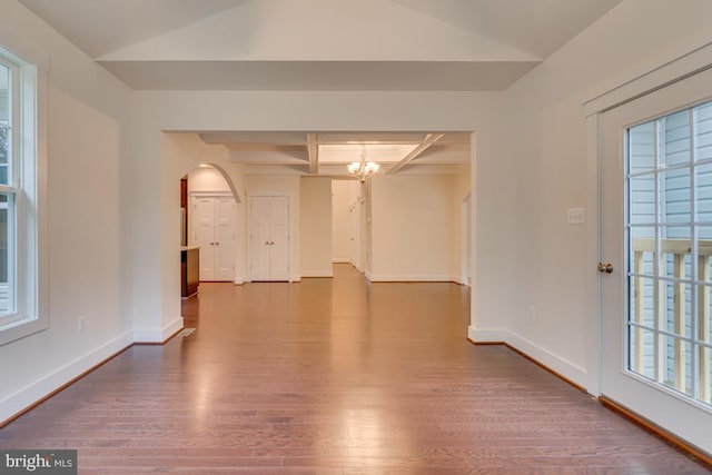 spare room with beam ceiling, a chandelier, coffered ceiling, and hardwood / wood-style floors