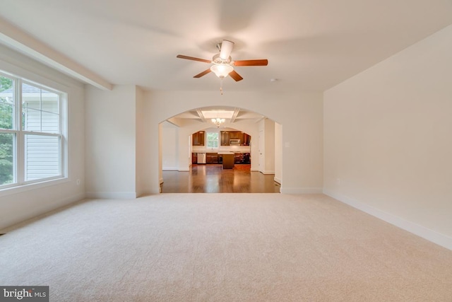 unfurnished living room with ceiling fan and dark carpet