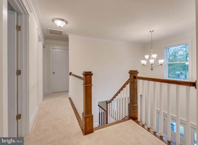 hallway featuring crown molding, light colored carpet, and an inviting chandelier