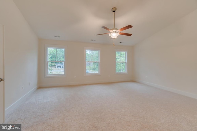 carpeted spare room featuring ceiling fan and lofted ceiling