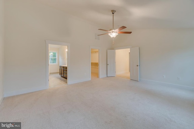 carpeted empty room with high vaulted ceiling and ceiling fan