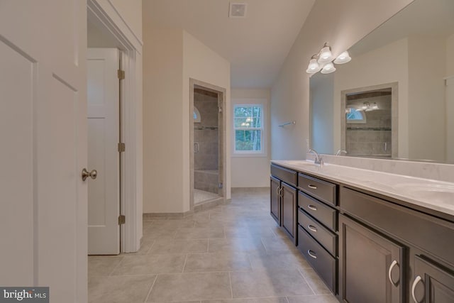 bathroom featuring tile patterned flooring, a shower with door, and vanity