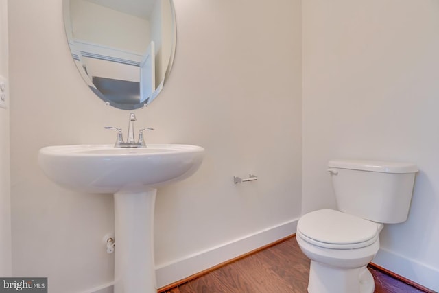 bathroom with toilet, hardwood / wood-style flooring, and sink