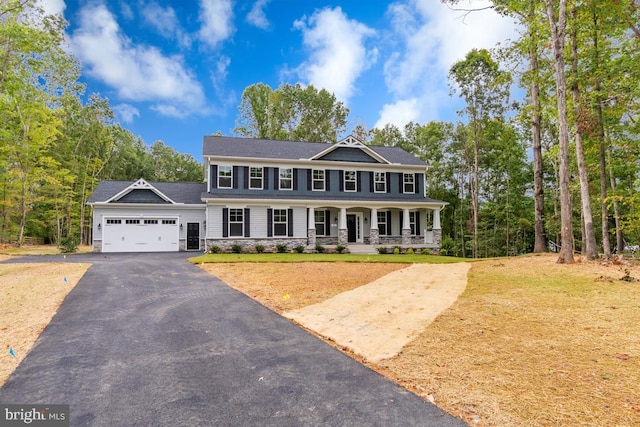 view of front of property with a garage, a front yard, and a porch