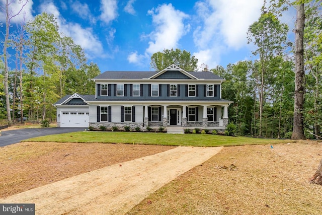 view of front facade featuring a front lawn, a garage, and a porch