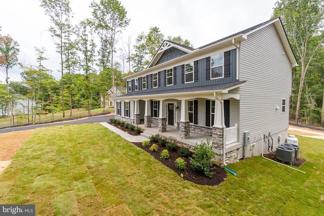 view of front of house featuring covered porch, a front yard, and central AC unit