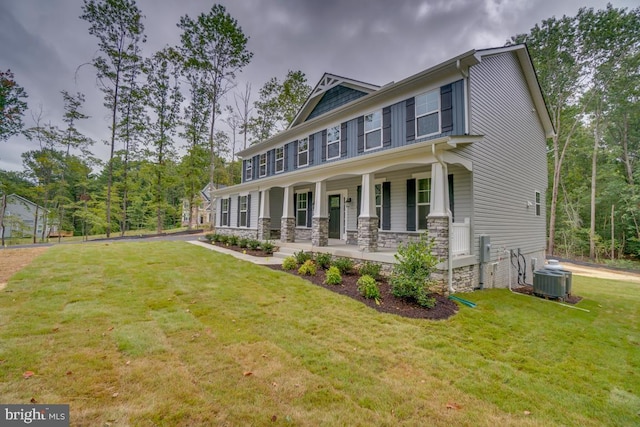 view of front of home with covered porch, central AC, and a front lawn