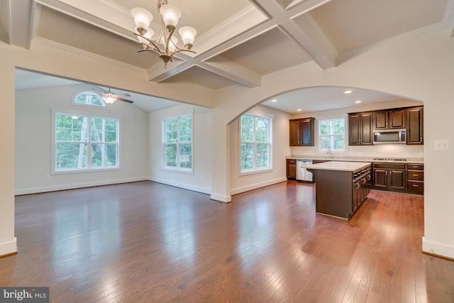 kitchen with decorative light fixtures, a center island, beamed ceiling, stainless steel appliances, and ceiling fan with notable chandelier