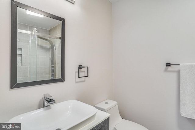 bathroom with walk in shower, sink, and toilet